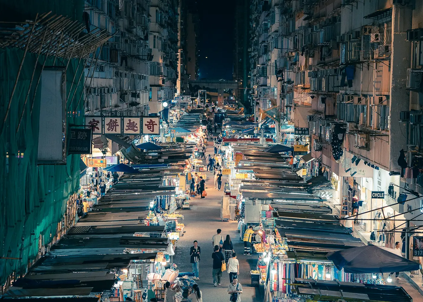 A night street seen from above, lit by stalls